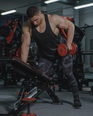 Man exercising with dumbbells in a gym setting